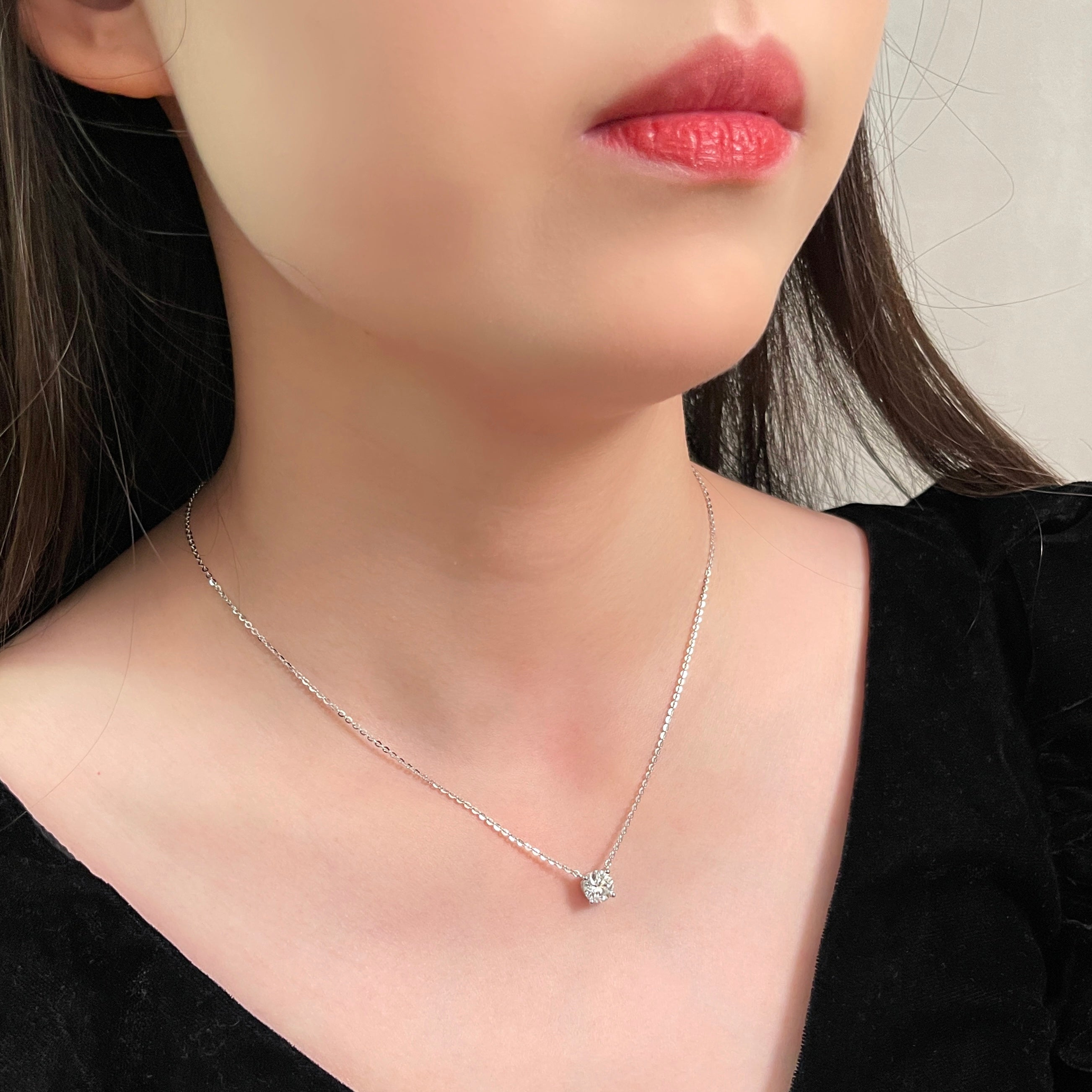 Side-profile view of a model wearing a 1.5 carat round lab grown diamond necklace in S925 sterling silver.