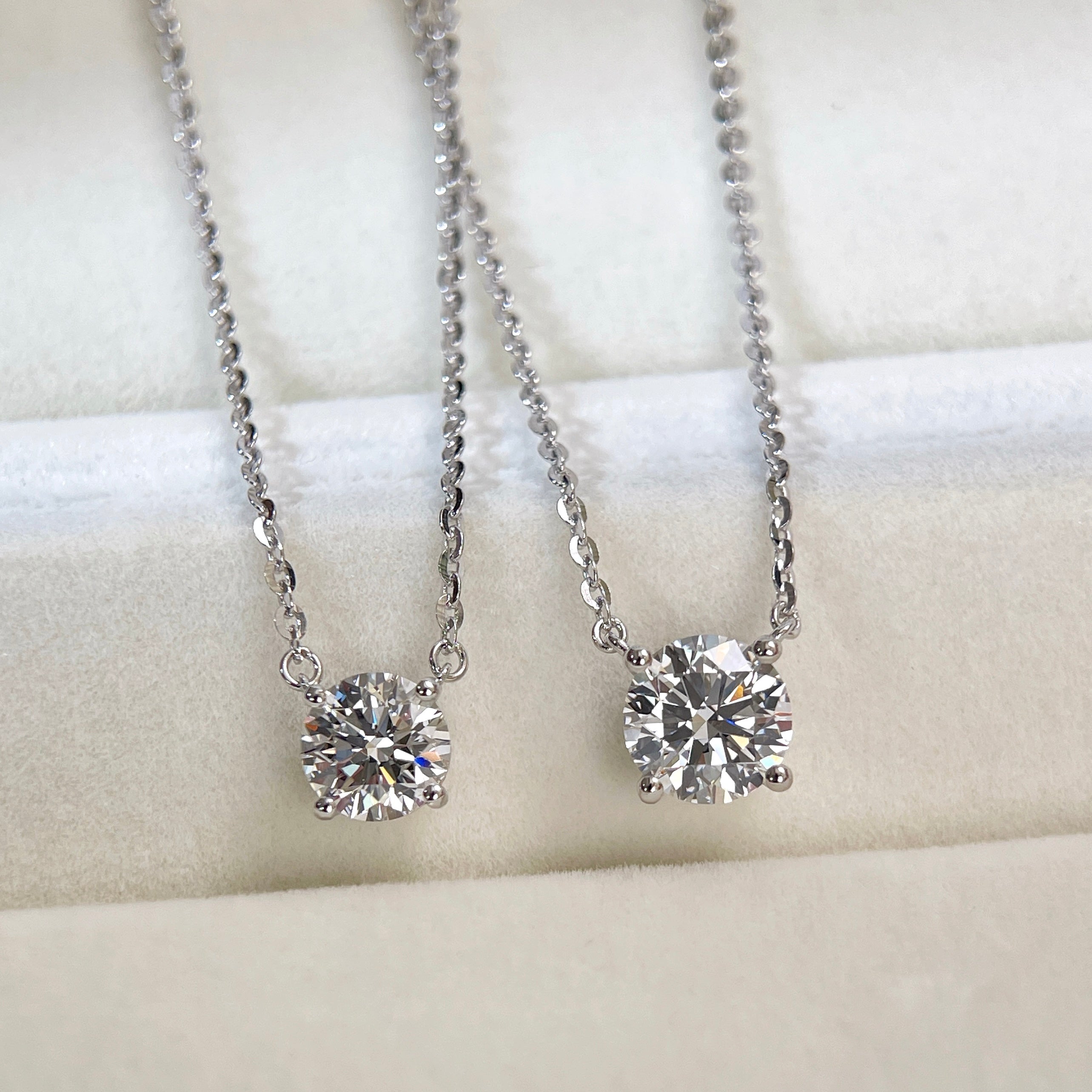 Front view comparing 1 CT and 1.5 CT round lab grown diamond necklaces.