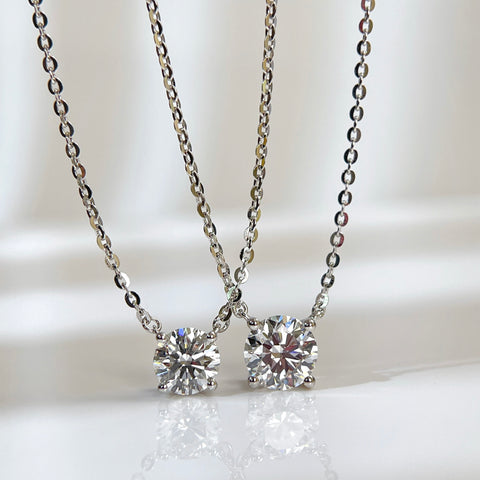 Jewelry display comparing 1 CT and 1.5 CT round lab grown diamond necklaces.