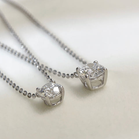Back setting view comparing 1 CT and 1.5 CT round lab grown diamond necklaces.
