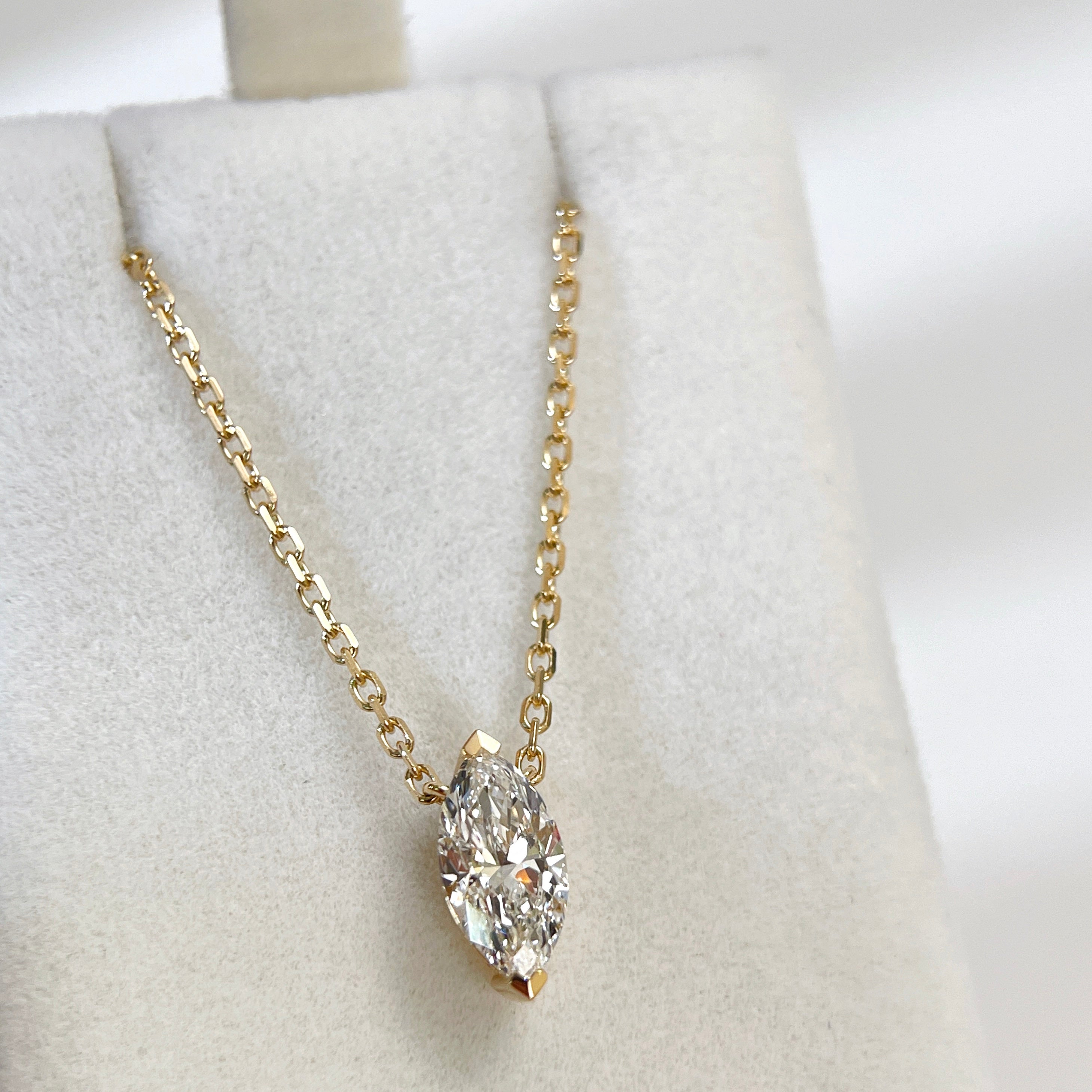 Front view of a 1 carat marquise lab grown diamond necklace in 18K yellow gold.
