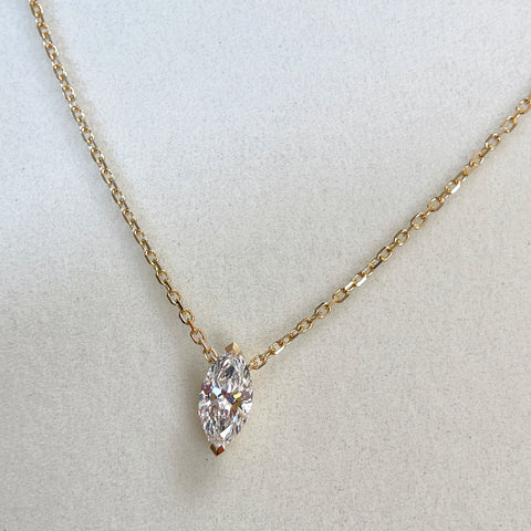 Jewelry display of a 1 carat marquise lab grown diamond necklace in 18K yellow gold.