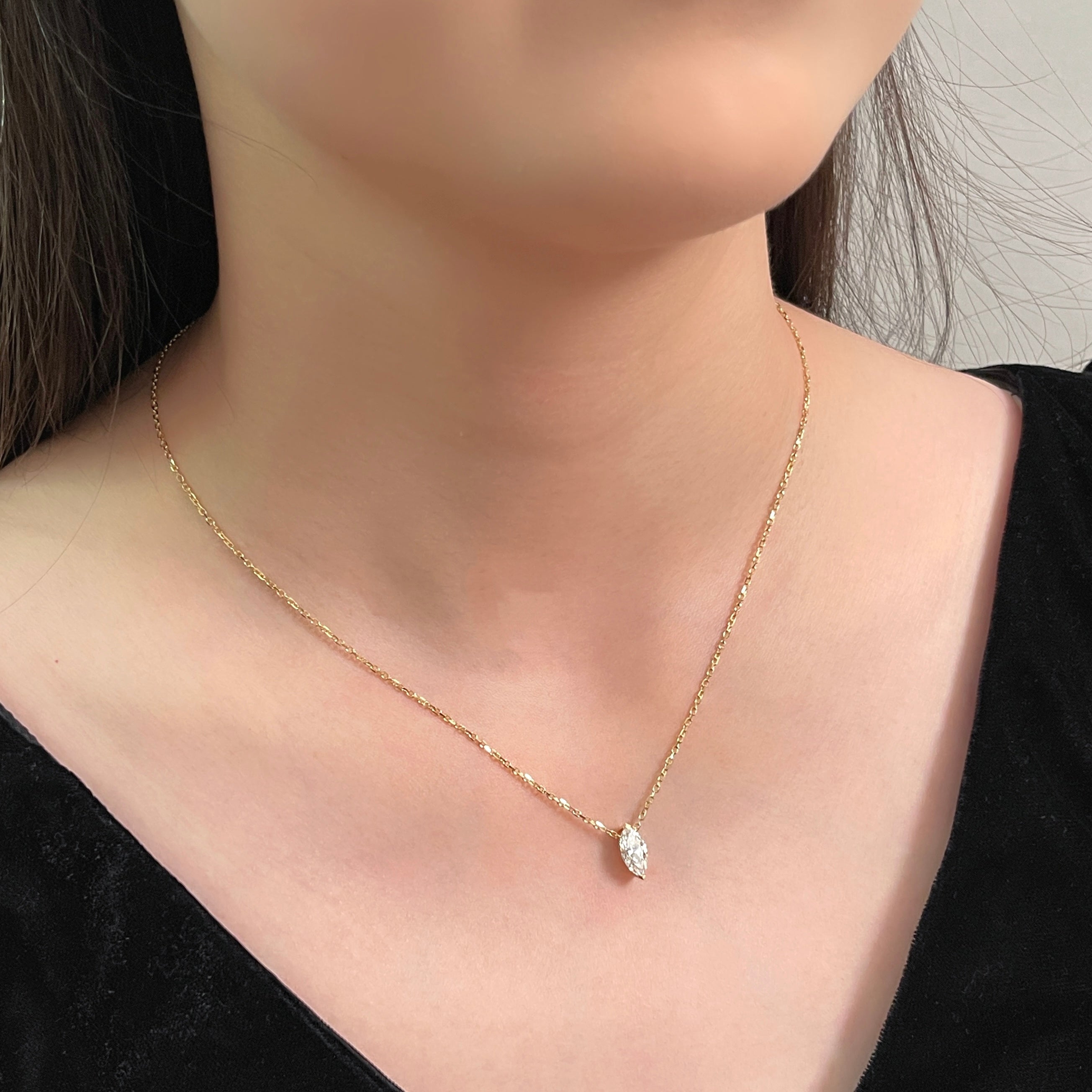 Model wearing a 1 carat marquise lab grown diamond necklace in 18K yellow gold.