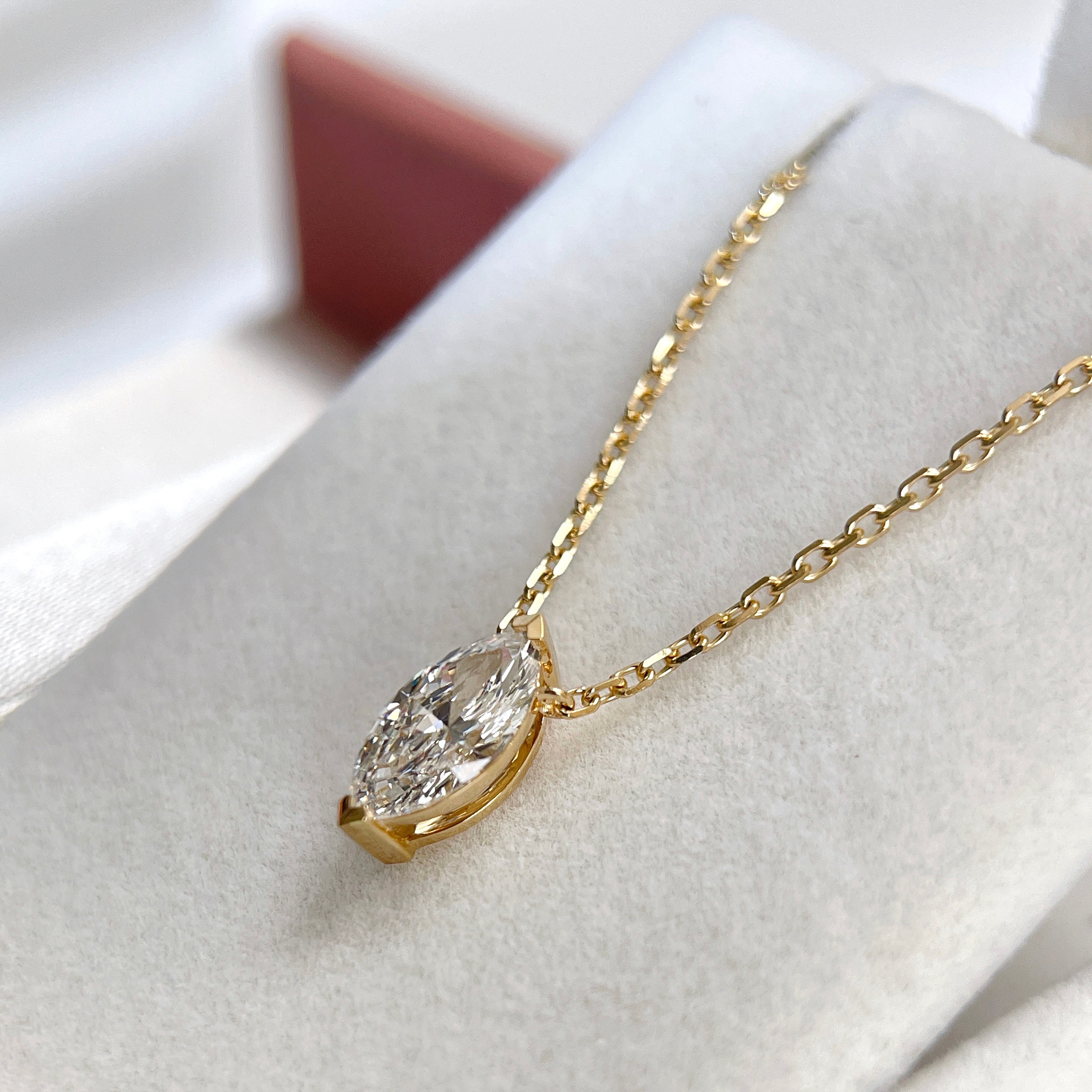 Side view showing the two-prong setting of a 1 carat marquise lab grown diamond necklace in 18K yellow gold.
