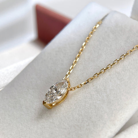 Side view showing the two-prong setting of a 1 carat marquise lab grown diamond necklace in 18K yellow gold.