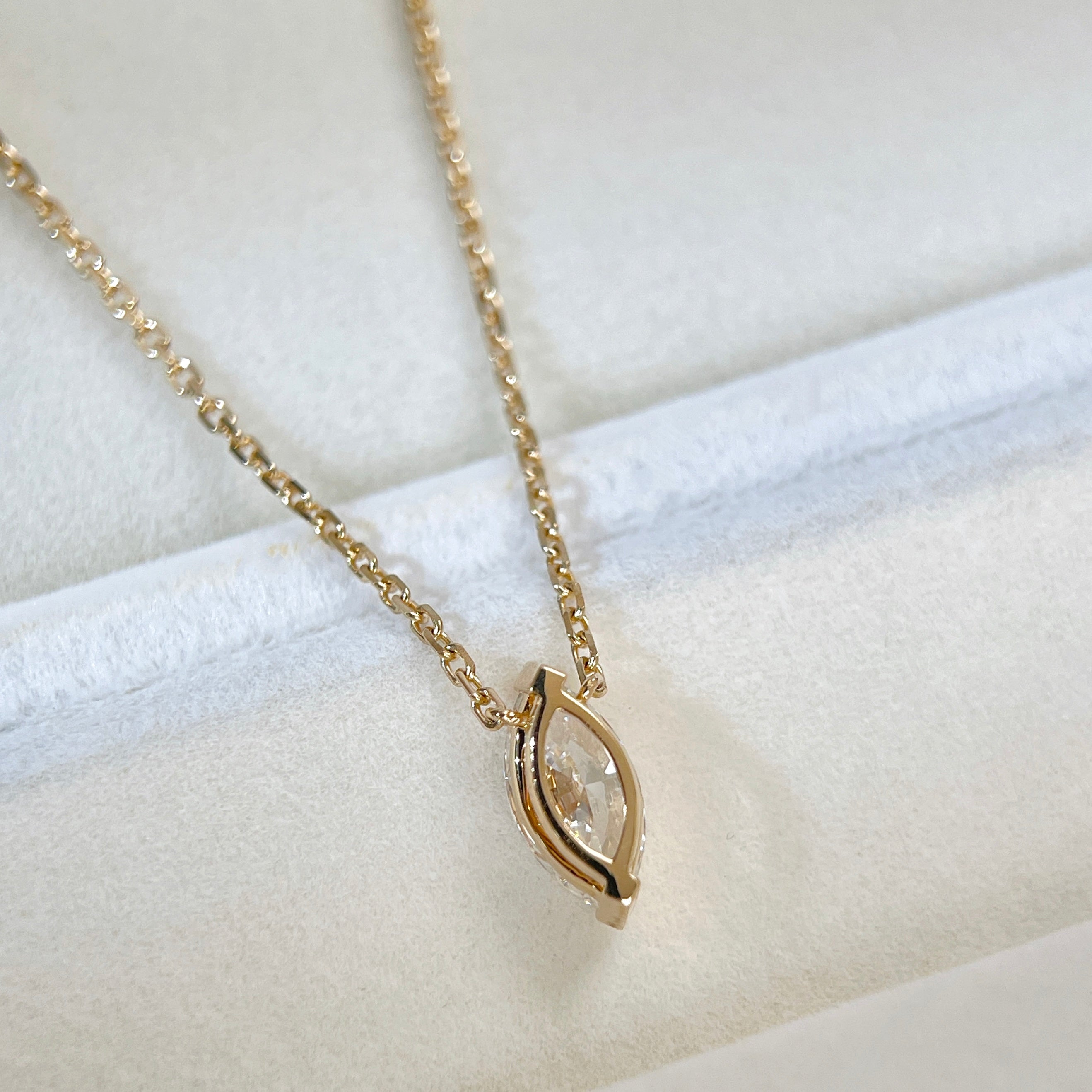 Back view showing the two-prong setting of a 1 carat marquise lab grown diamond necklace in 18K yellow gold.