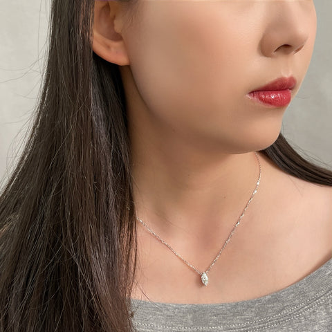 Side-profile view of a model wearing a 1 carat marquise lab grown diamond necklace in S925 sterling silver.