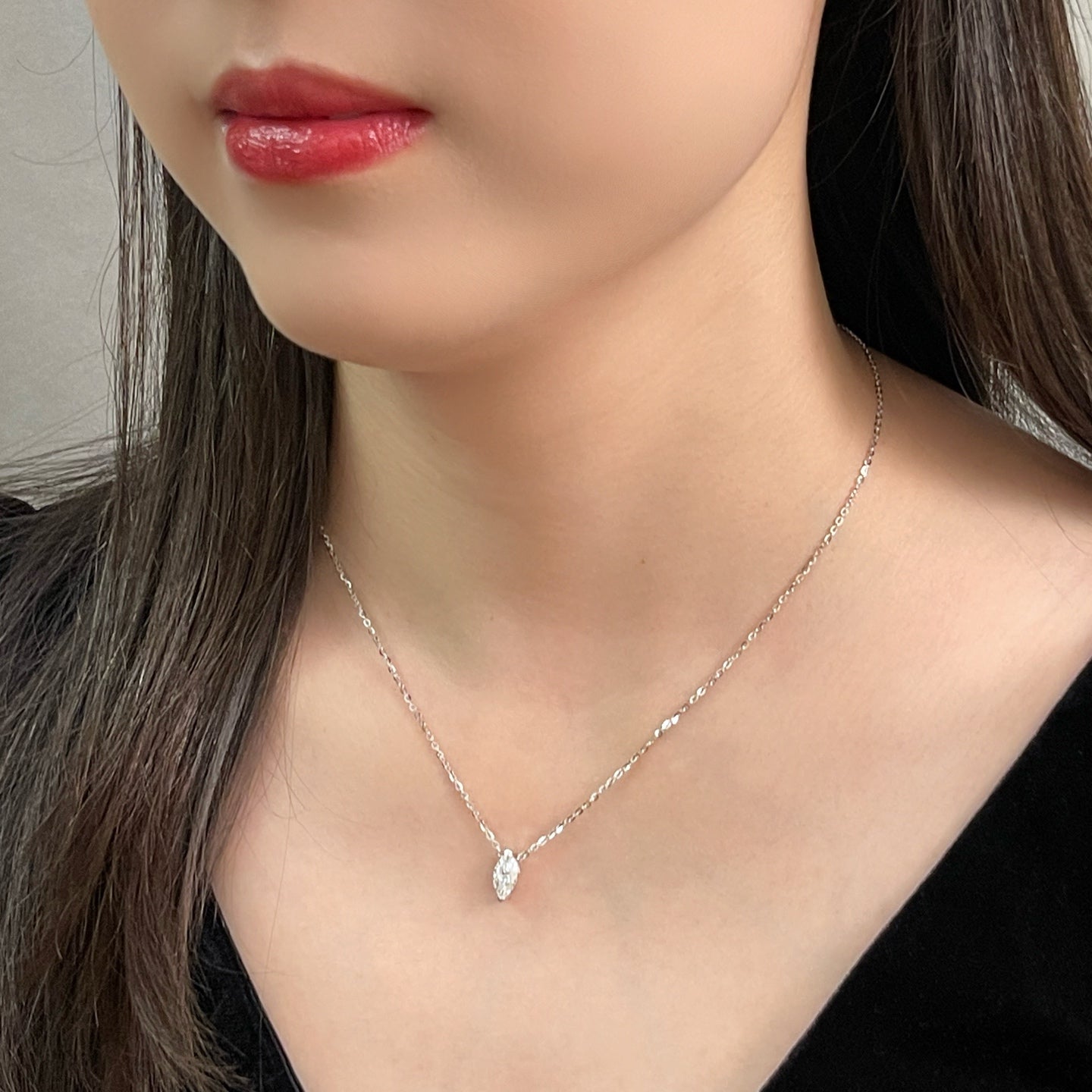 Close-up of a model wearing a 1 carat marquise lab grown diamond necklace in S925 sterling silver.