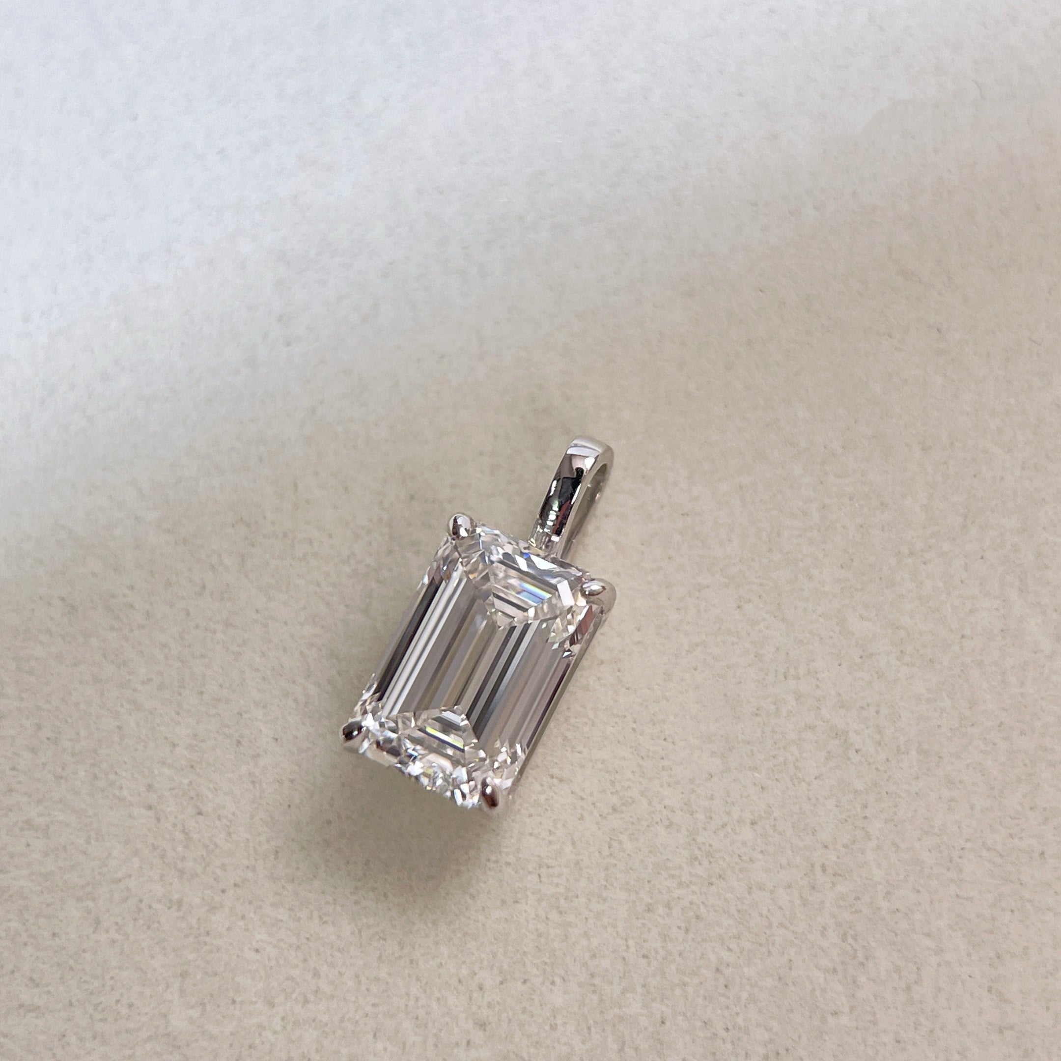 Front view of a detachable 2 ct emerald-cut lab grown diamond pendant in 18K white gold