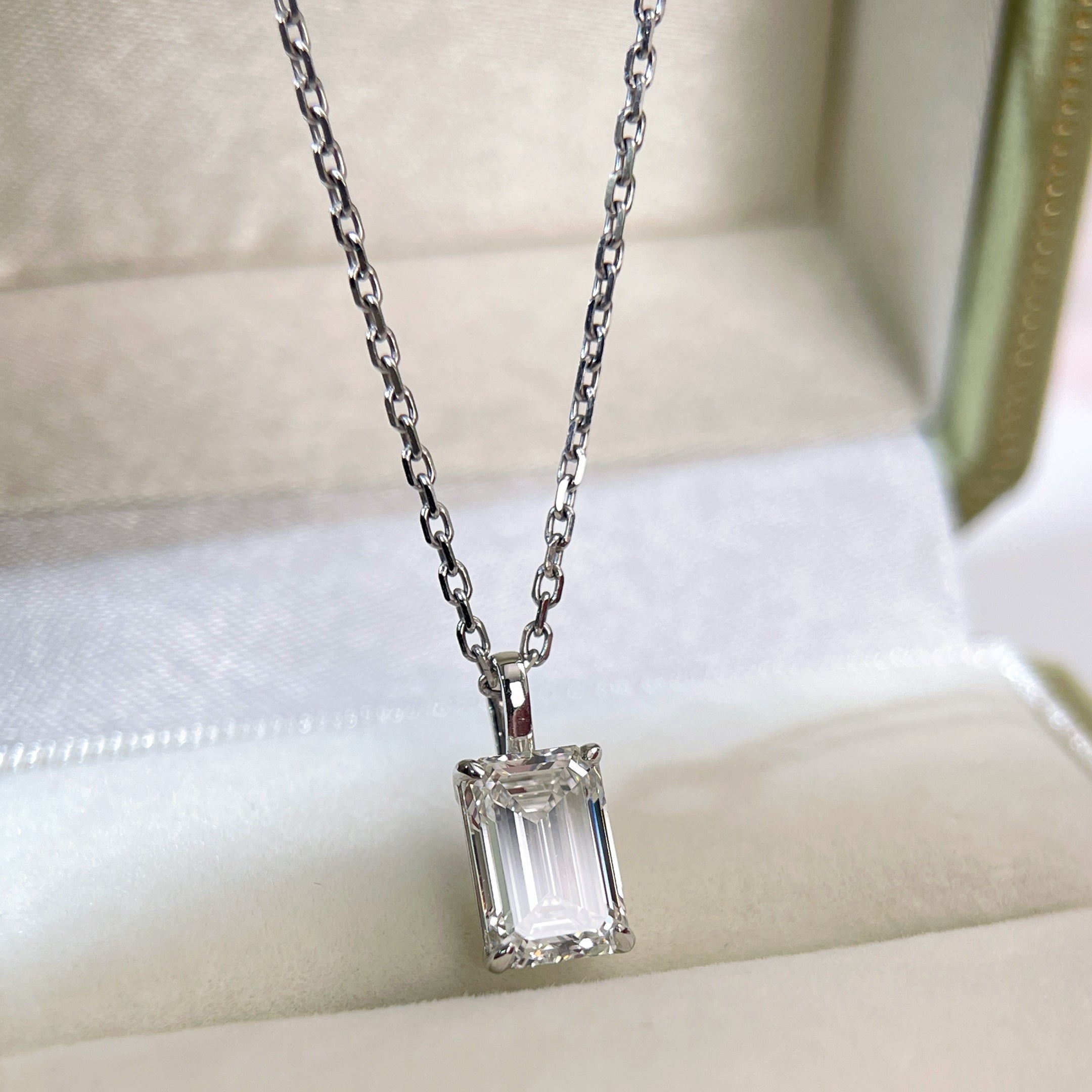 Angled jewelry box display of a 2 ct emerald-cut lab grown diamond pendant with a separate chain