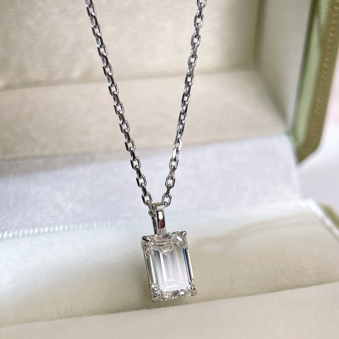 Angled jewelry box display of a 2 ct emerald-cut lab grown diamond pendant with a separate chain