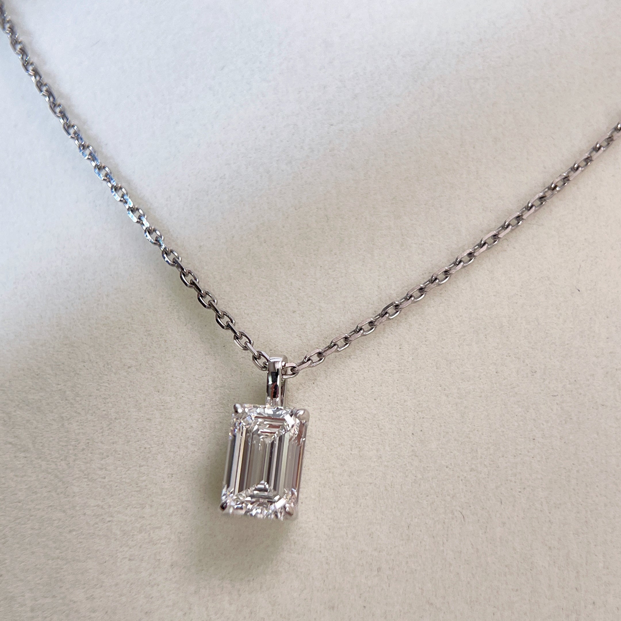 Centered display of a 2 ct emerald-cut lab grown diamond pendant on its separate chain