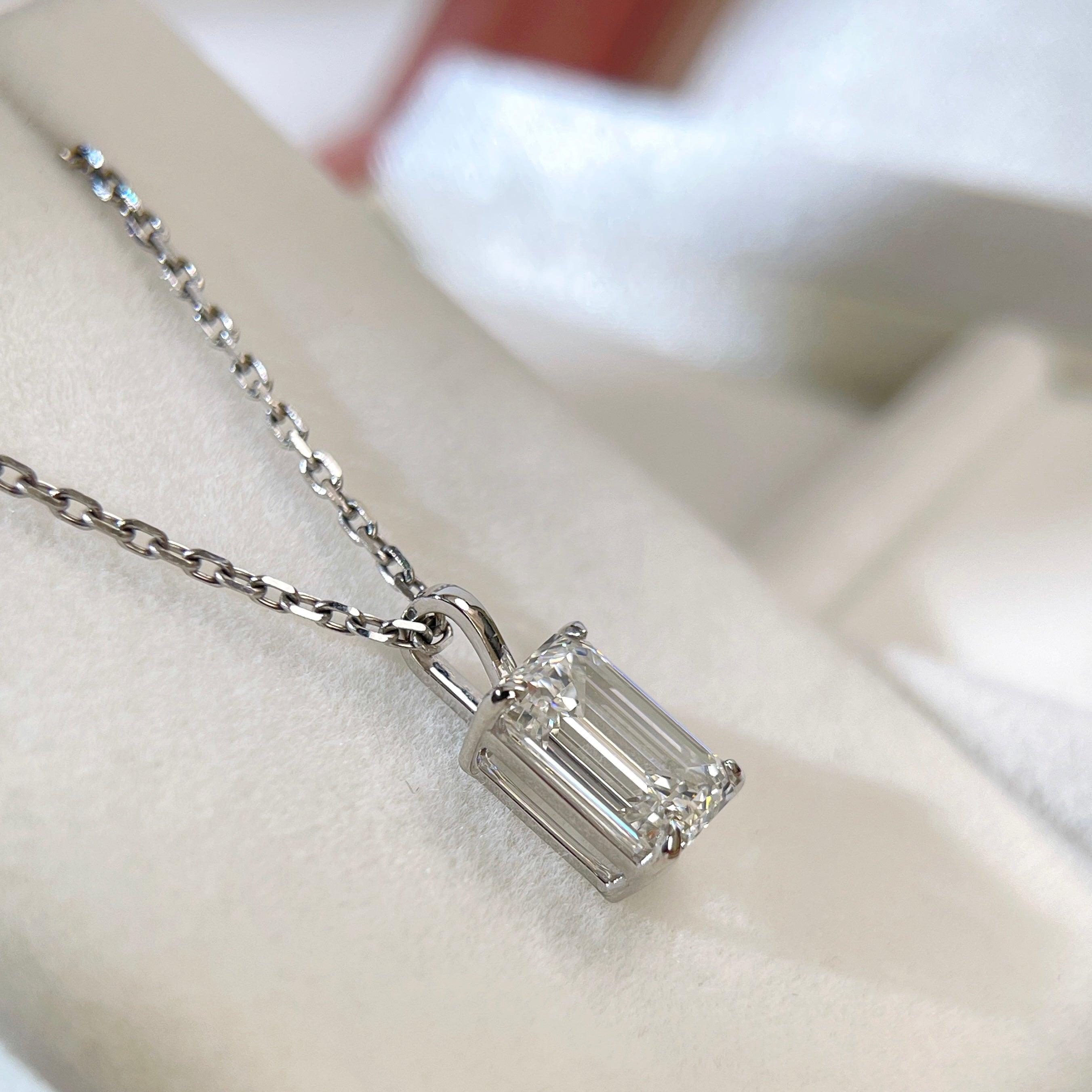 Angled detail of the four-prong basket and bail on a 2 ct emerald-cut lab grown diamond pendant