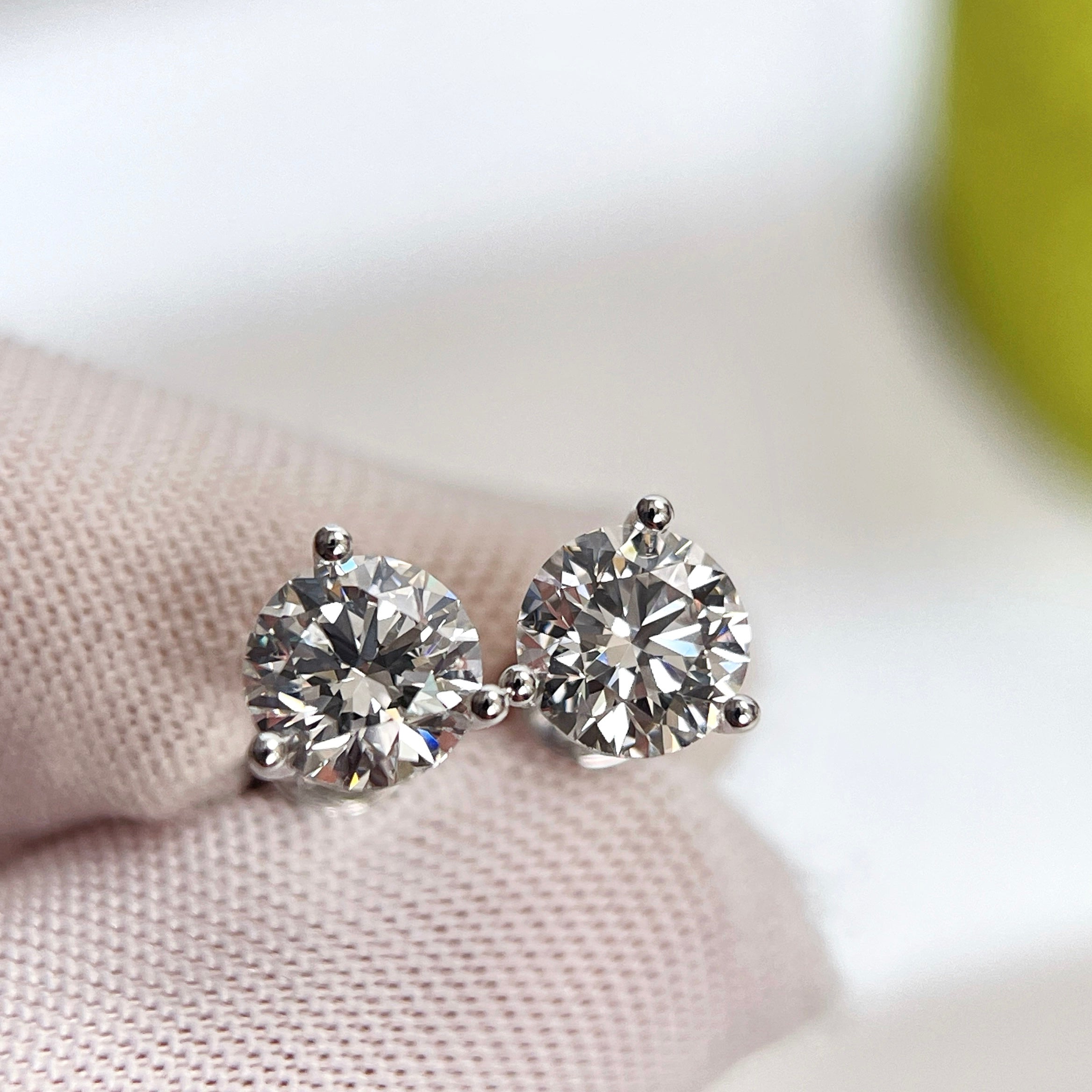Front close-up of 2 CTW round lab grown diamond three-prong Martini stud earrings