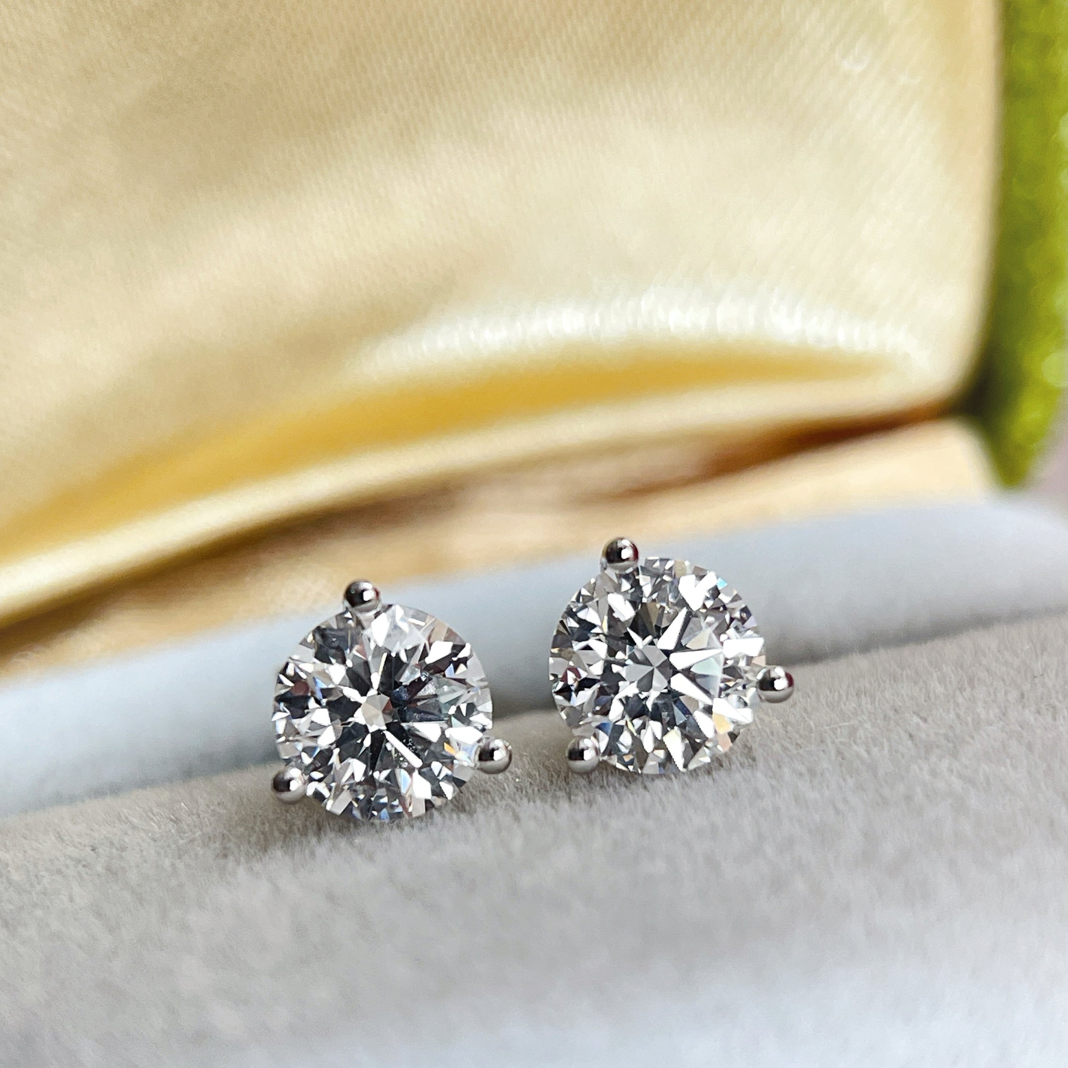 Two 1 carat round lab grown diamonds in three-prong Martini stud settings