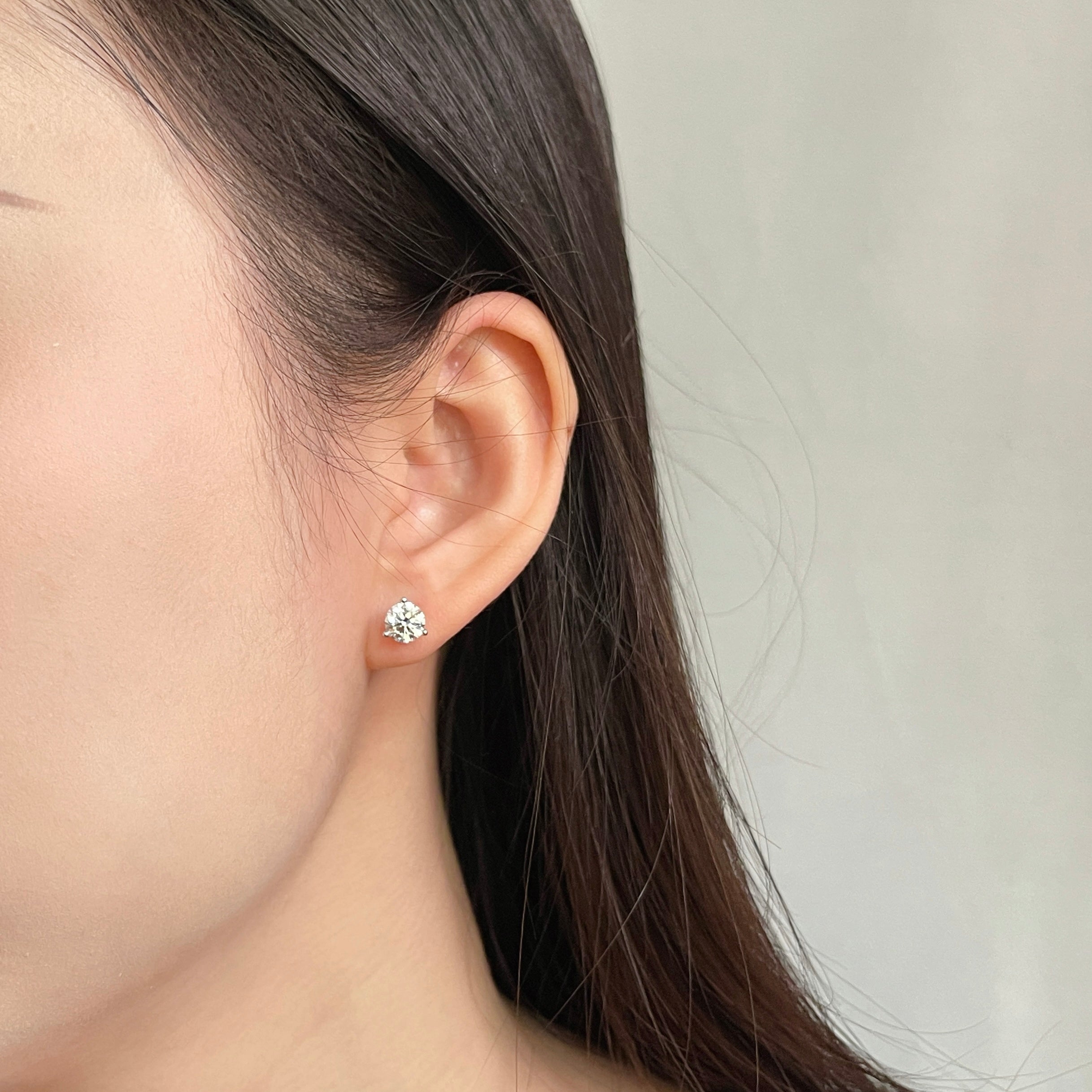 Close-up of a model wearing a 1 carat round lab grown diamond Martini stud earring
