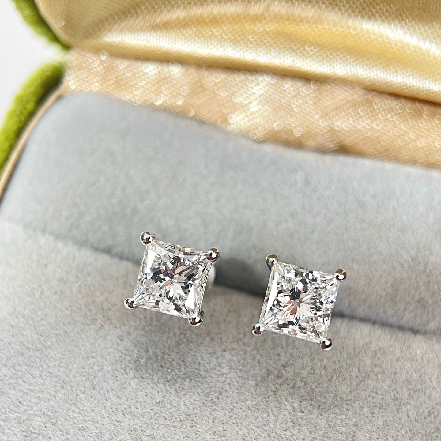 Princess-cut lab-grown diamond stud earrings displayed in a jewelry box