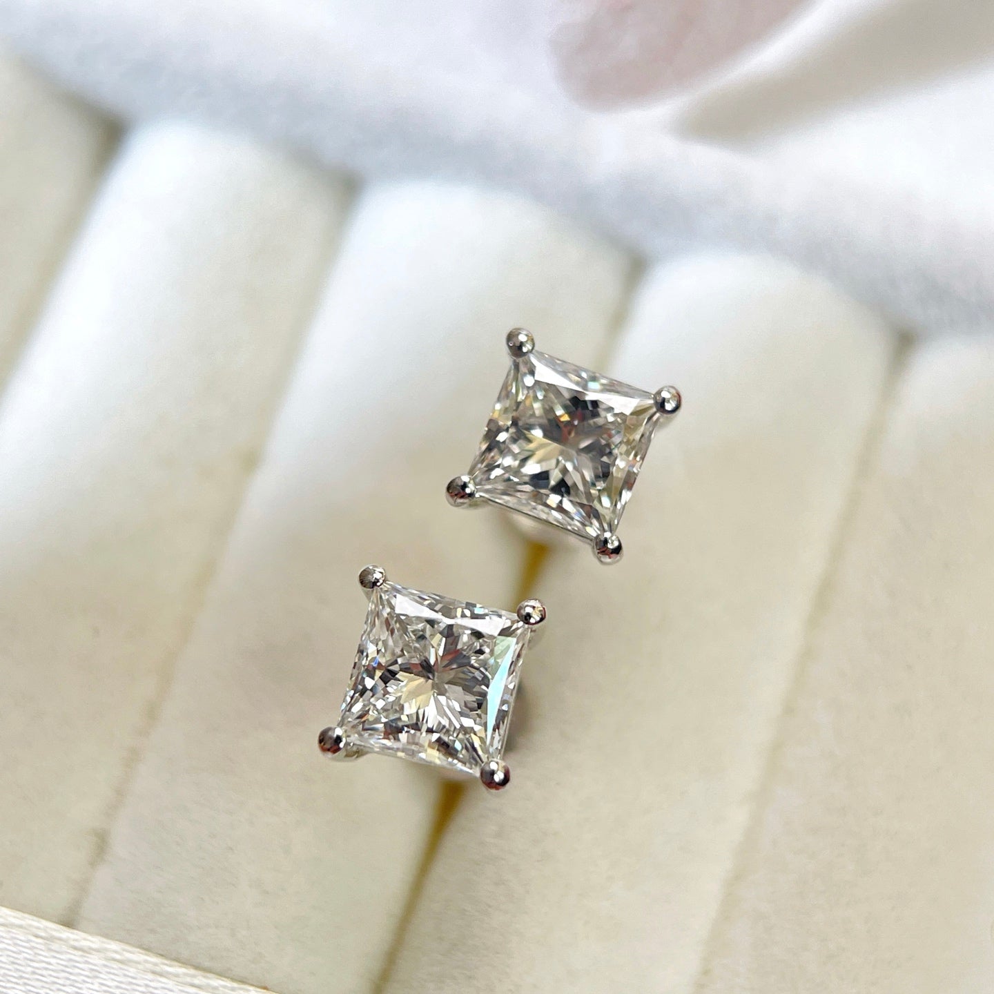 Angled jewelry box view of 2 CTW princess-cut lab-grown diamond stud earrings