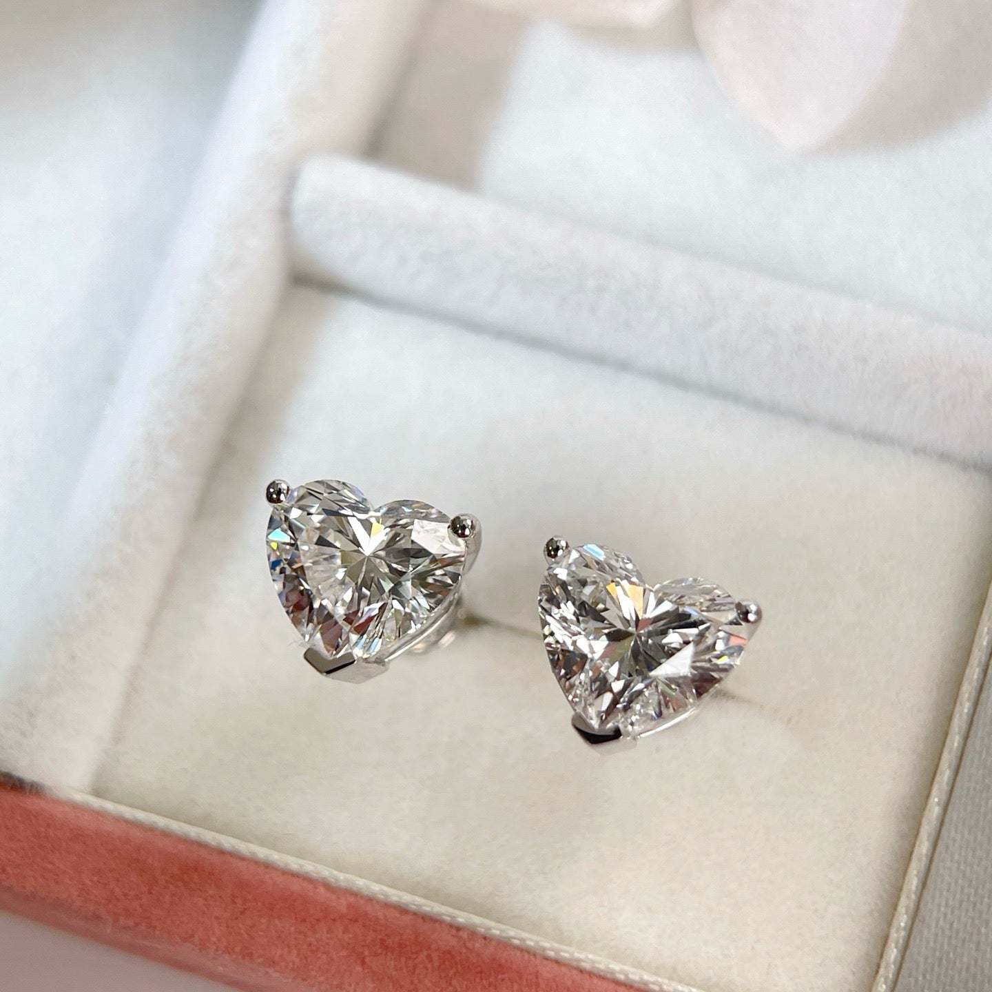 Heart-shaped lab-grown diamond stud earrings displayed in a jewelry box