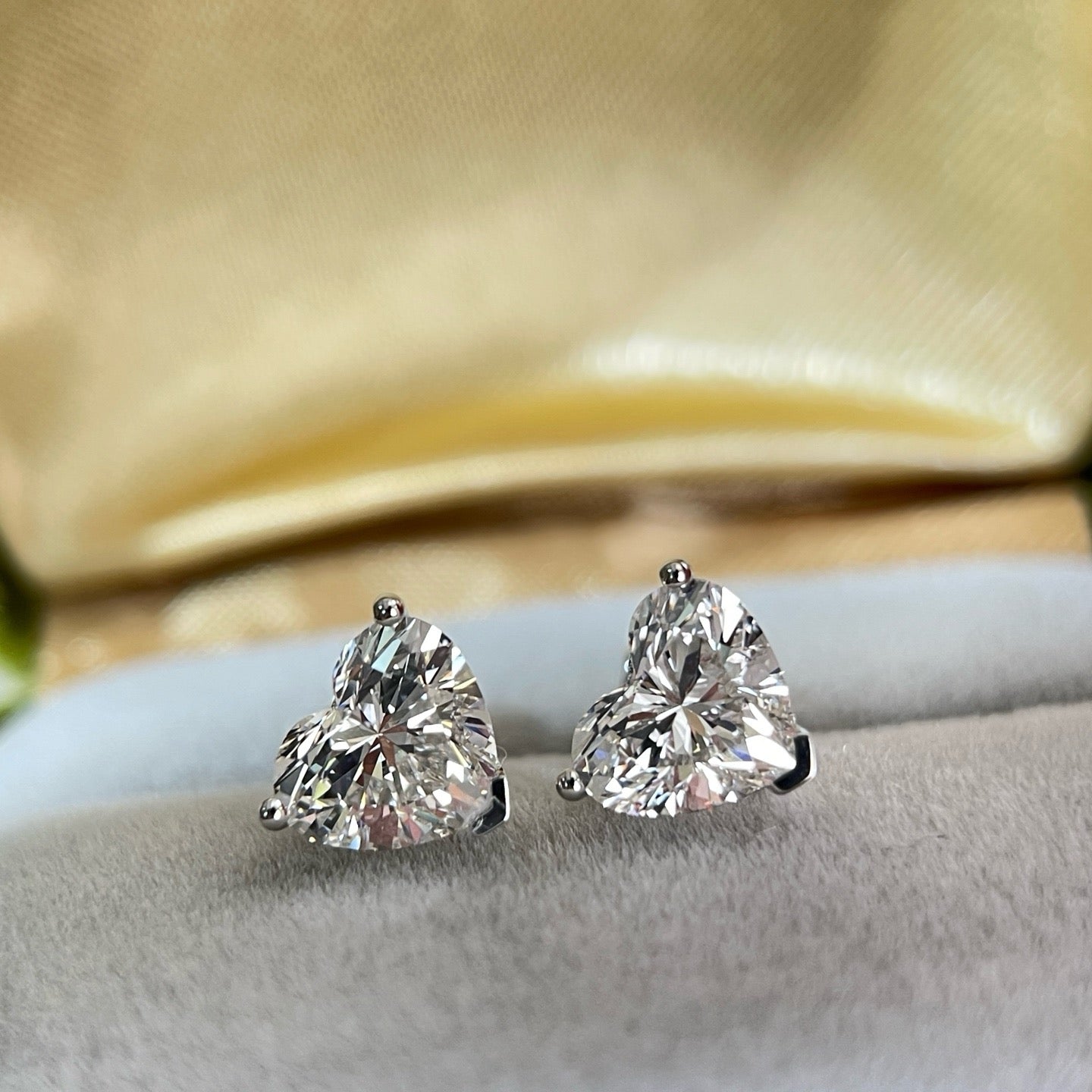 Front display view of heart-shaped lab-grown diamond three-prong stud earrings