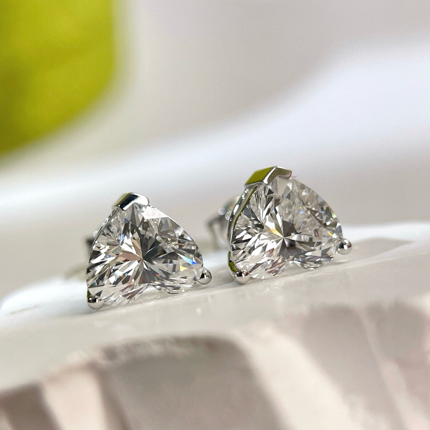 Side view showing the three-prong settings of heart-shaped diamond stud earrings
