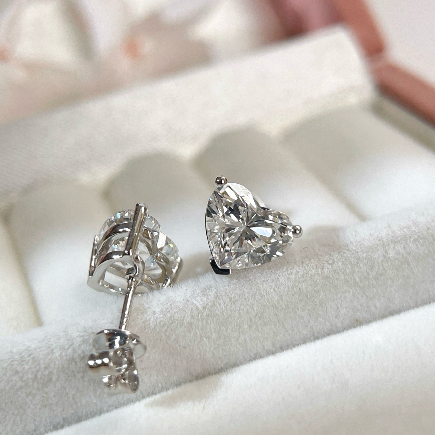 Angled back view of 18K white gold heart-shaped diamond stud earrings