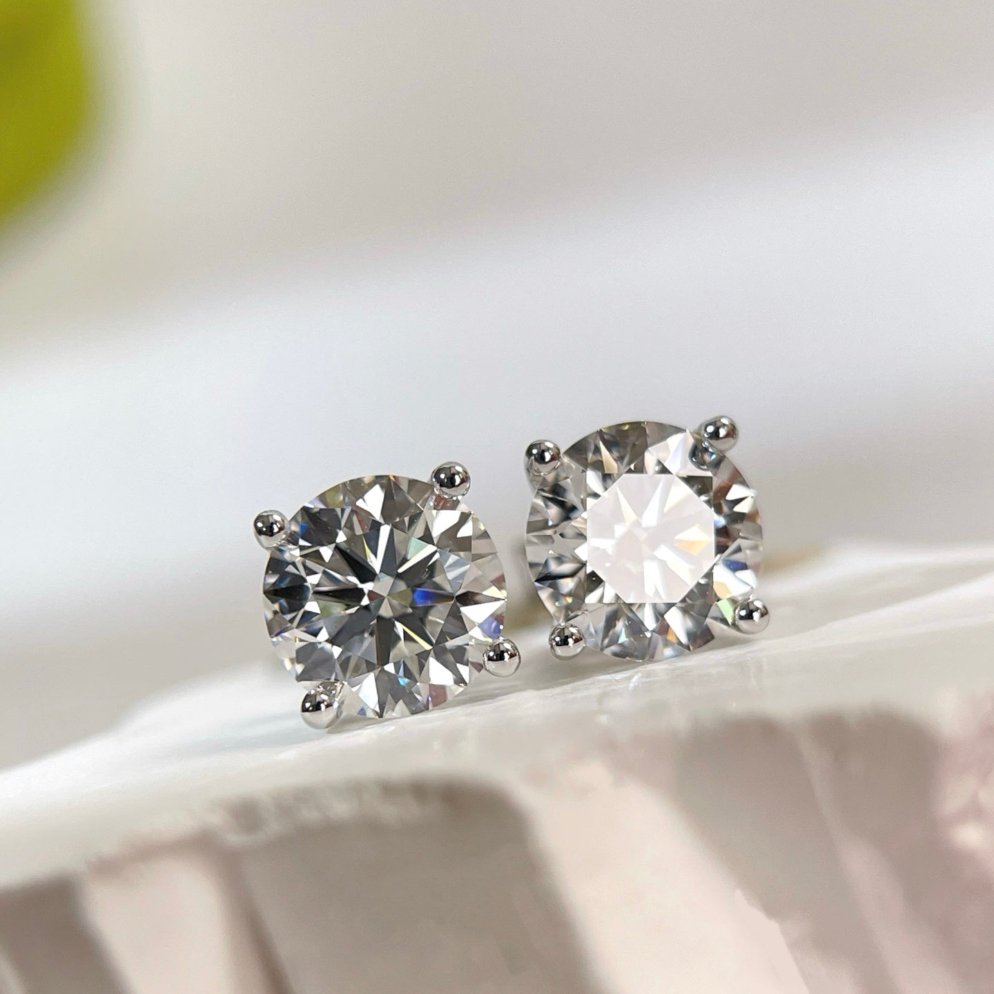 Front view of 3 CTW D VVS2 round lab grown diamond four-prong stud earrings