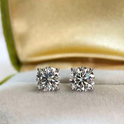 3 CTW round lab grown diamond four-prong stud earrings on a jewelry display