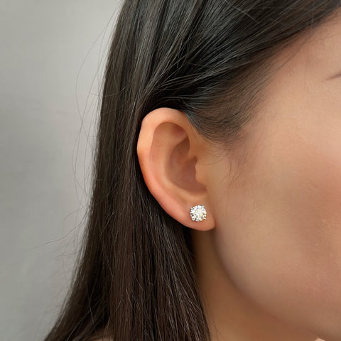 Model wearing 3 CTW round lab grown diamond four-prong stud earrings