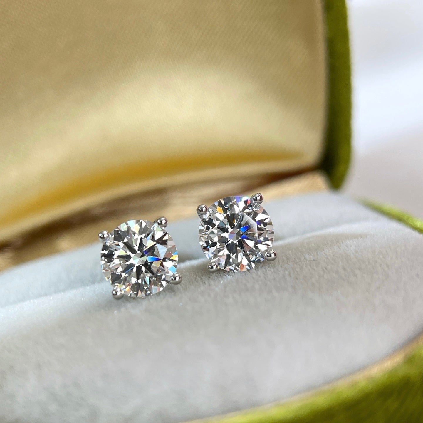 3 CTW round lab grown diamond four-prong stud earrings displayed in a jewelry box