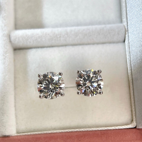 Top view of 3 CTW round lab grown diamond stud earrings in a jewelry box