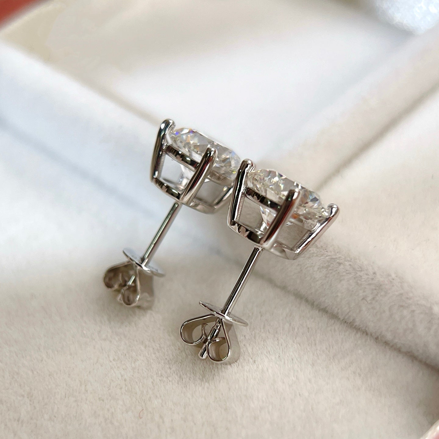 Side and back construction of 18K white gold four-prong diamond stud earrings