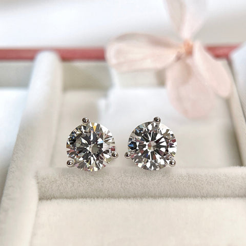 3 CTW round lab grown diamond three-prong Martini stud earrings on a jewelry display