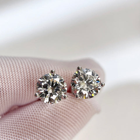 Gloved-hand close-up of D VVS2 round lab grown diamond Martini stud earrings