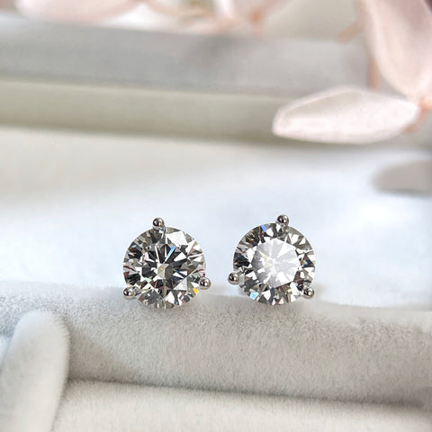 Angled display view of 3 CTW round lab grown diamond three-prong stud earrings