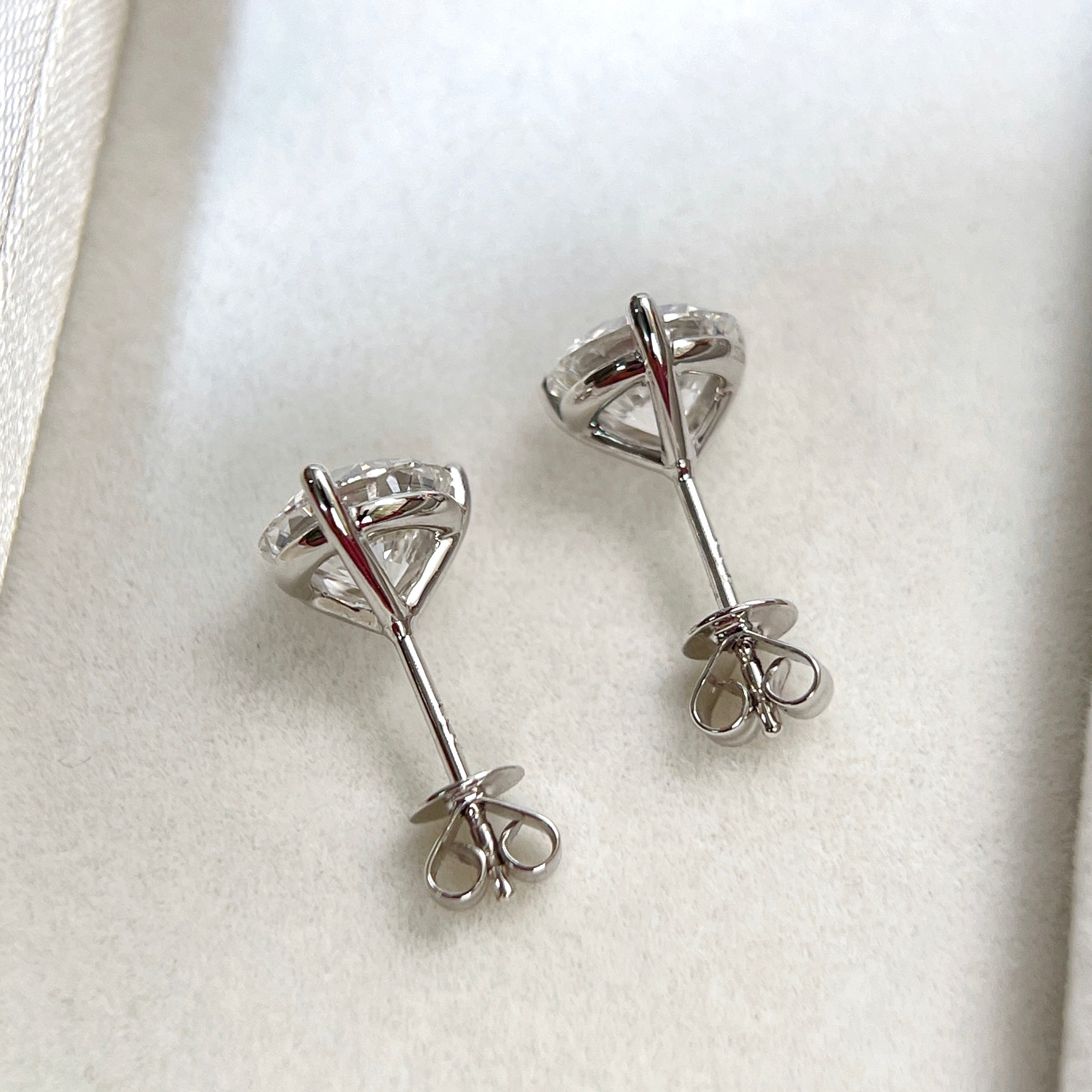 Back view of 18K white gold three-prong Martini stud earrings with push backs
